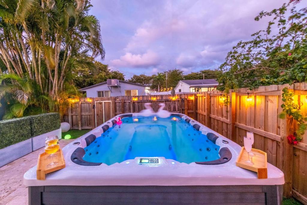 a backyard pool with a hot tub in the yard at 4BR Hollywood Villa 3 min to Beach, Heated 12-Person Jacuzzi, Game Room and BBQ in Hollywood