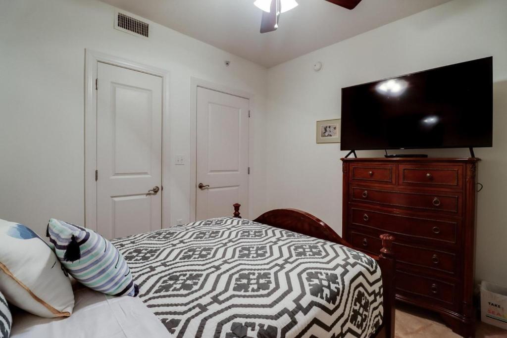 a bedroom with a bed and a dresser with a flat screen tv at Capri On The Biloxi Coast in Biloxi