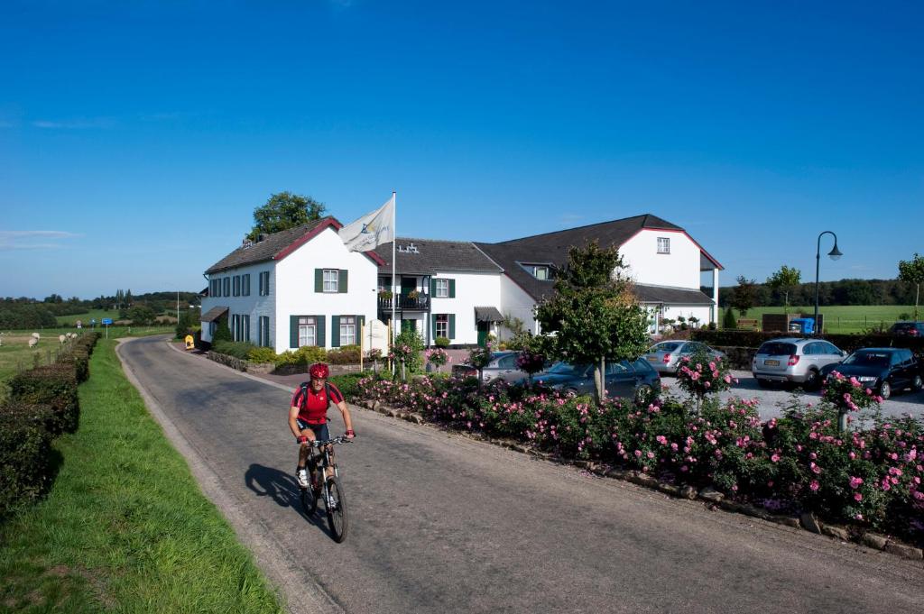 een persoon die fietst over een weg bij Hotel Gerardushoeve in Heijenrath