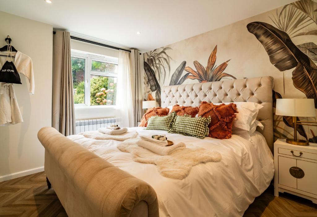 Un dormitorio con una gran cama blanca con mantas encima. en Priory Bay Escapes - Uminari, en Tenby