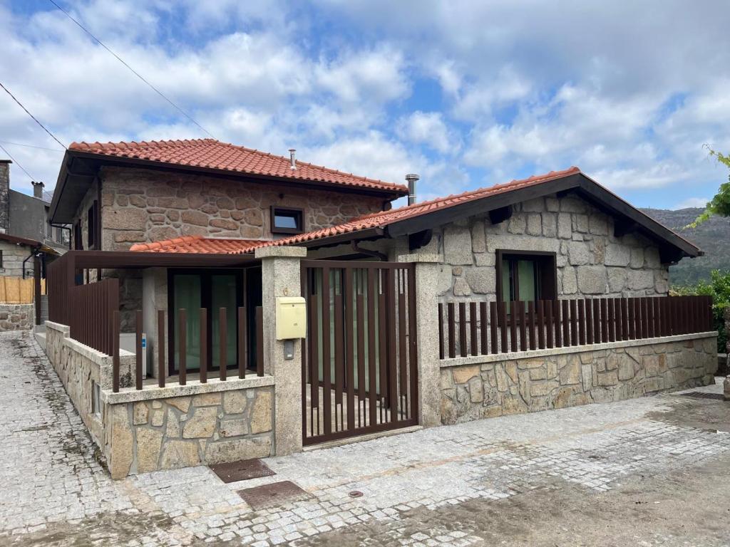 una piccola casa in pietra con cancello in legno di Cantinho da Cuca - Gerês a Terras de Bouro