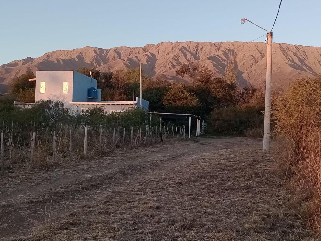 a dirt road with a house and mountains in the background at Aire de lavandas in La Paz