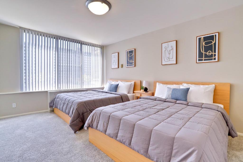 a bedroom with two beds and a window at Stylish Apt - Pool Gym & Close to DC in Arlington