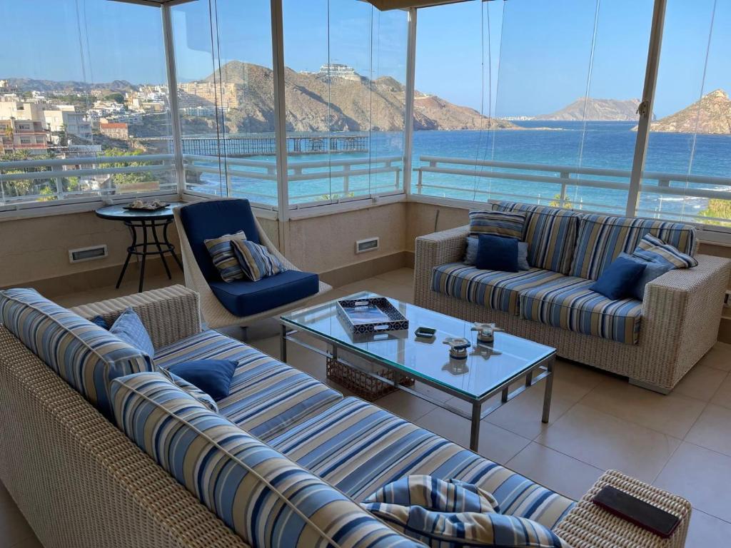 a living room with couches and a view of the ocean at Ático Dos Bahías in Águilas