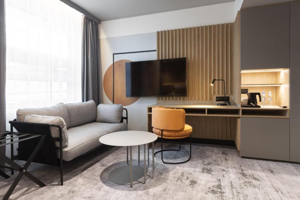 a living room with a couch and a table at voco Katowice by IHG in Katowice