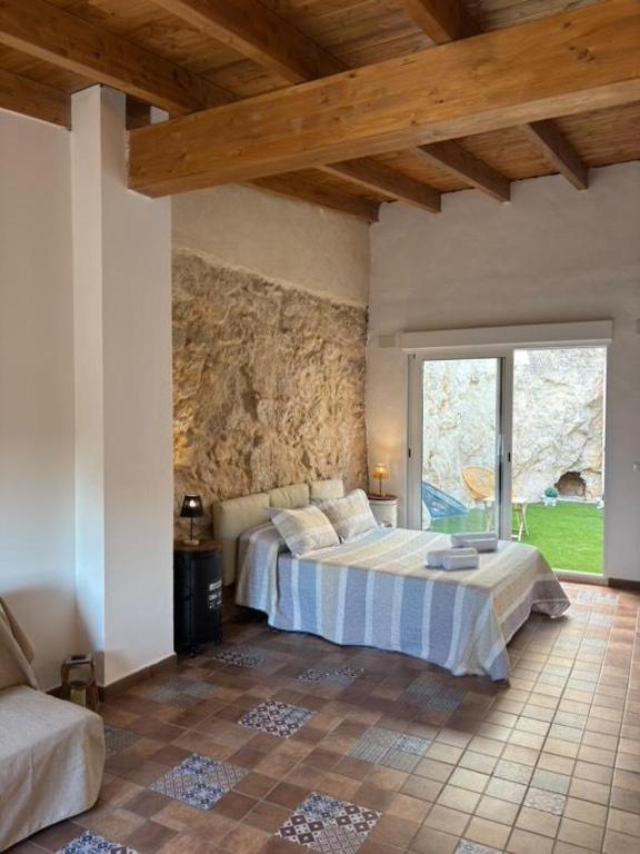 a bedroom with a bed and a stone wall at Casa Isabella in Xàtiva