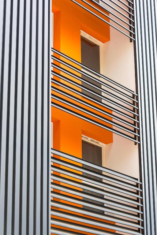 an orange and white building with balconies at Ténéo Apparthôtel Bordeaux Maritime - Cité du vin in Bordeaux