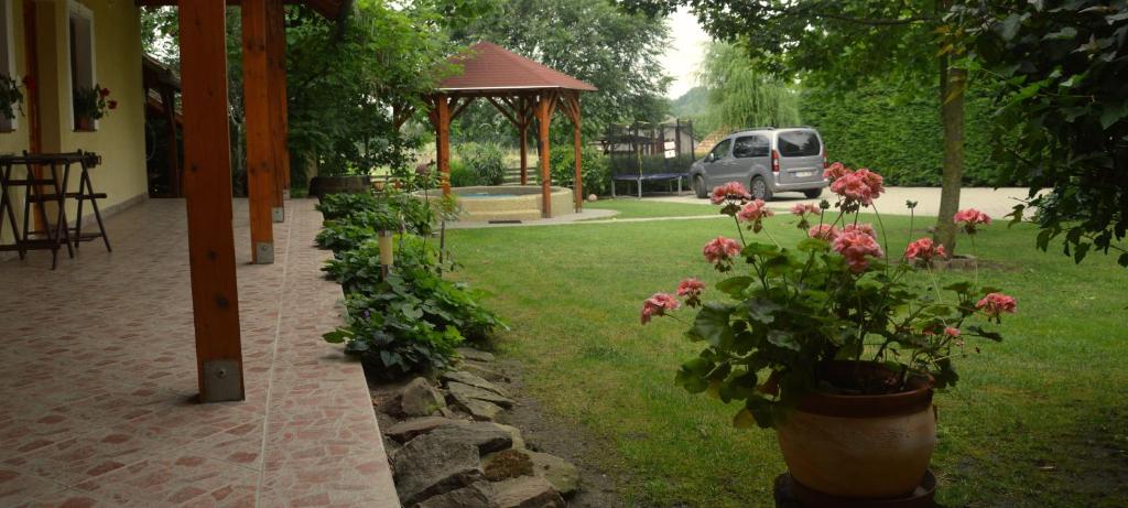 un jardín con flores y un cenador en Tisza-Kert Vendégház -Tisza-Kert Vendégház II, en Tiszafüred