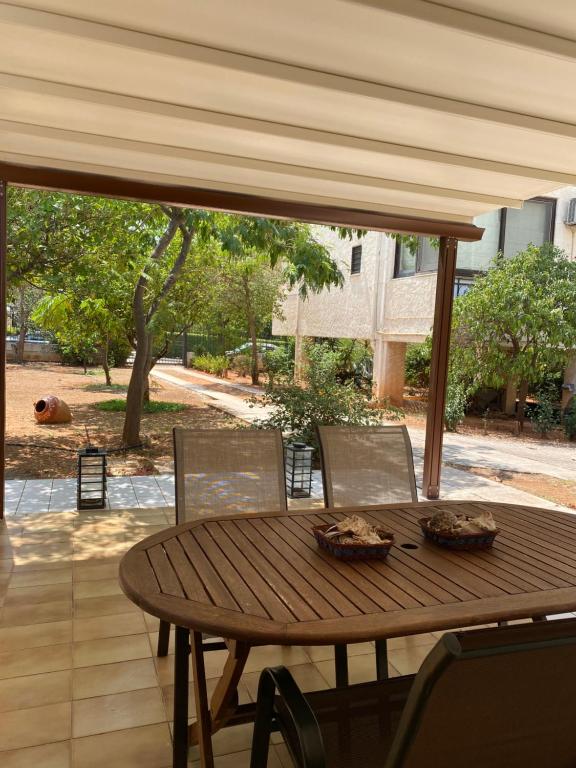 アテネにあるGlyfada Charm, Little home with private parkingのパティオにある木製のテーブルと椅子