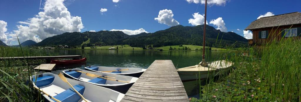 two boats are docked at a dock on a lake at Appartements Herwig Schwarzenbacher in Weissensee