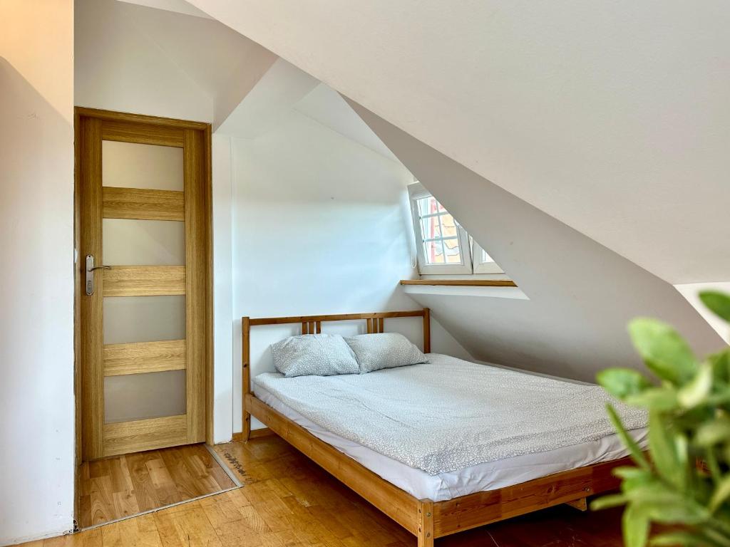 a small bedroom with a bed in a attic at Pokoje przy SKM Sopot Wyścigi in Sopot