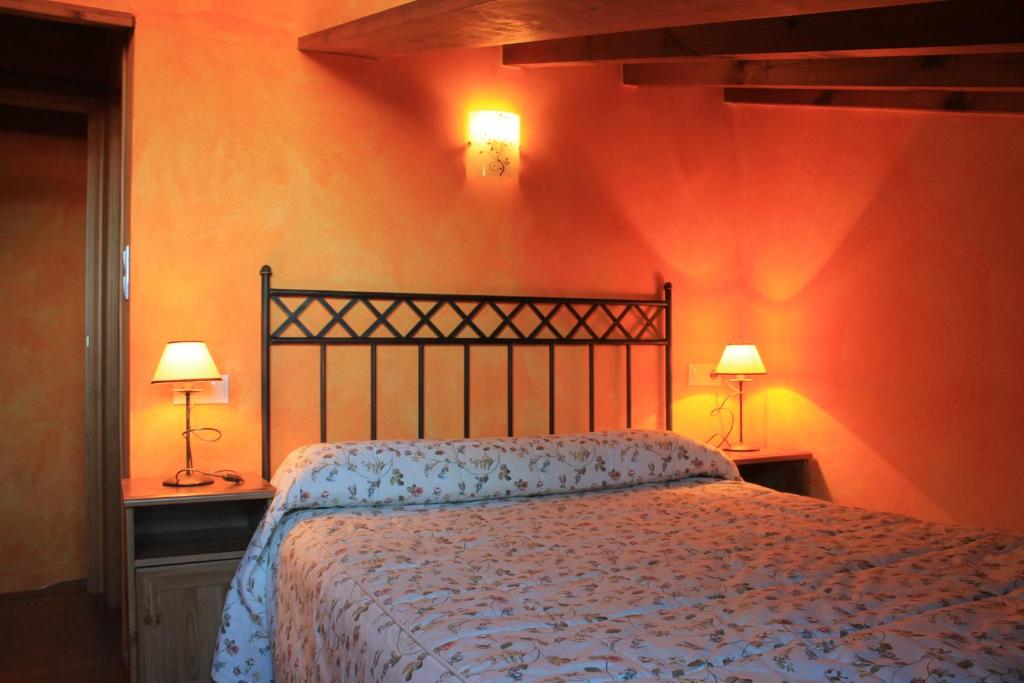 1 dormitorio con 1 cama y 2 lámparas en las mesas en Apartamentos Los Rosales, en Ponga