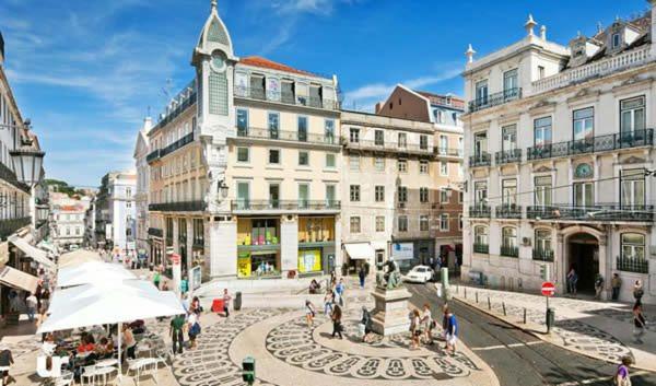 リンダ・ア・ヴェーリャにある2 bedroom apartment in Lisbonの建物のある街歩きの人々