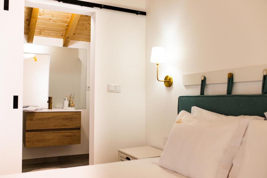 une chambre avec un lit et une salle de bain avec un lavabo dans l'établissement Casas do Freixial - Casa das Flores, à Fundão