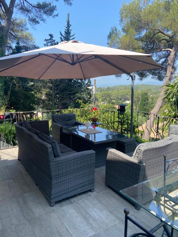eine Terrasse mit Tisch und Sonnenschirm in der Unterkunft Cocon in Le Cannet