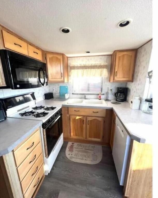 a kitchen with wooden cabinets and a stove top oven at Rogue River Landing Resort Cabins in Gold Beach