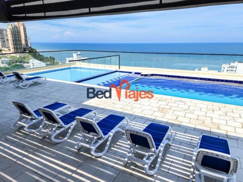 grupa krzeseł ustawionych obok basenu w obiekcie Apartamento con piscina en el rodadero Eificio VITA w mieście Rodadero