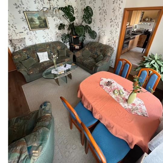 a living room with a table and chairs and a couch at Harz und Gemütlich in Blankenburg