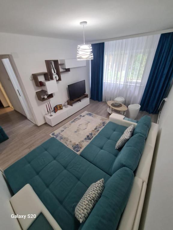 un salon avec un canapé et une télévision dans l'établissement Apartament Central Slanic-Moldova, à Slănic-Moldova