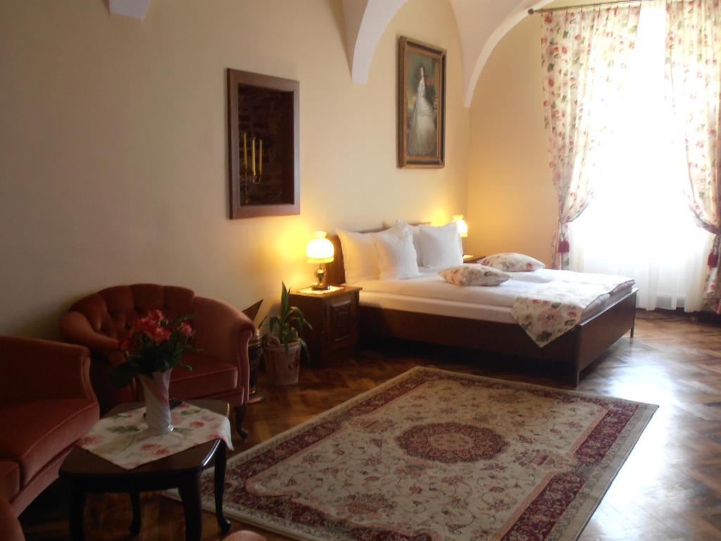 a bedroom with a bed and a couch and a chair at Gothic House in Sibiu