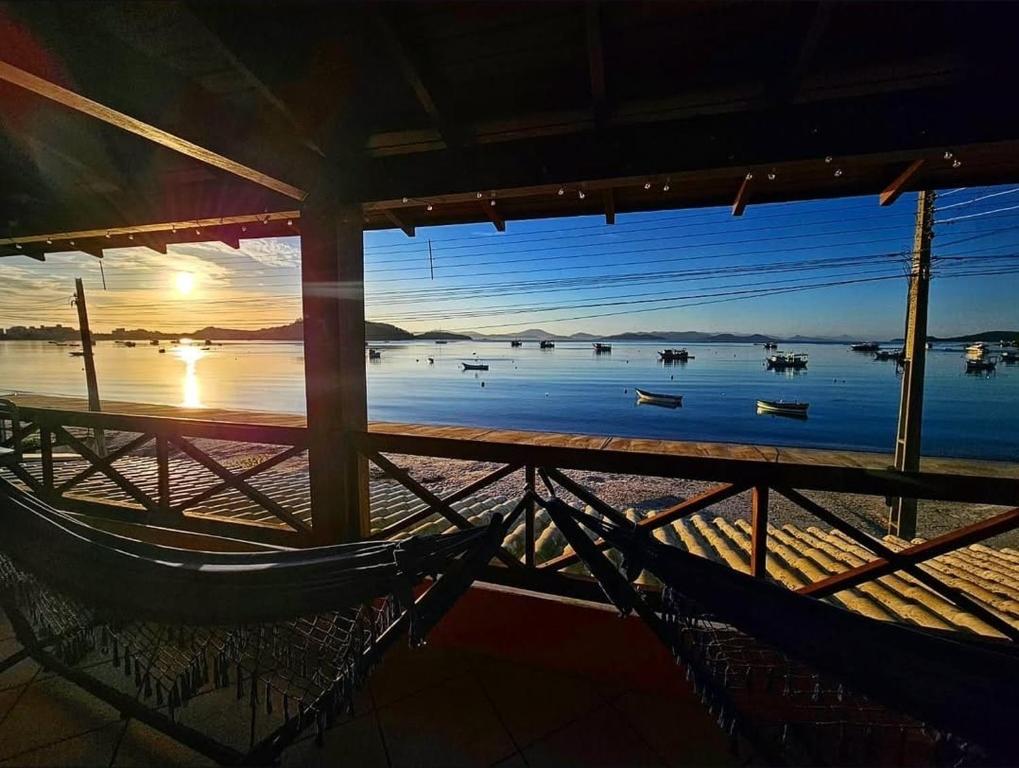 a hammock on a beach with a view of the water at Aspidiske in Governador Celso Ramos