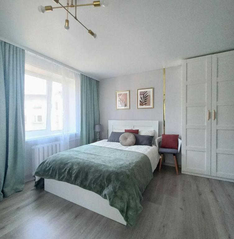 a bedroom with a large bed and a window at Narva Vibe Apartment in Narva