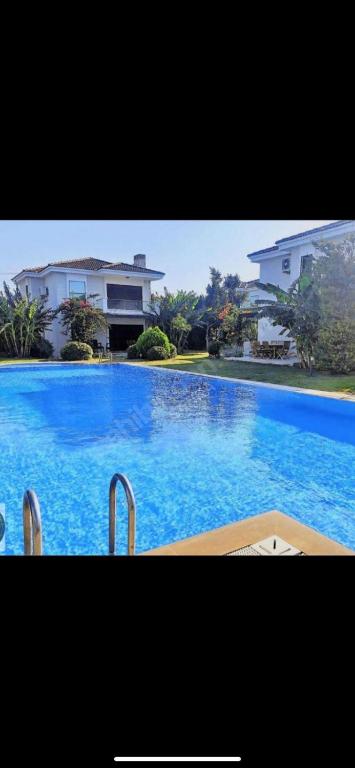 una grande piscina blu davanti a una casa di Villa Tego a Çeşme