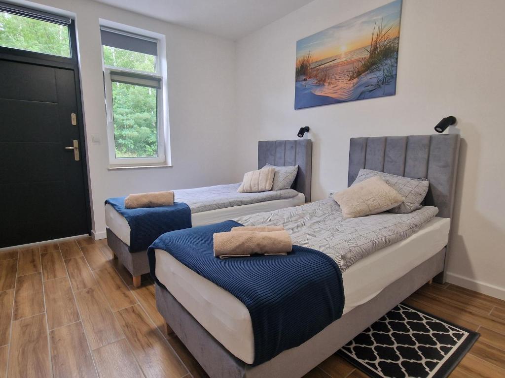 1 Schlafzimmer mit 2 Betten und einer Tür in der Unterkunft Słoneczne pokoje nad jeziorem Nyskim in Skorochow