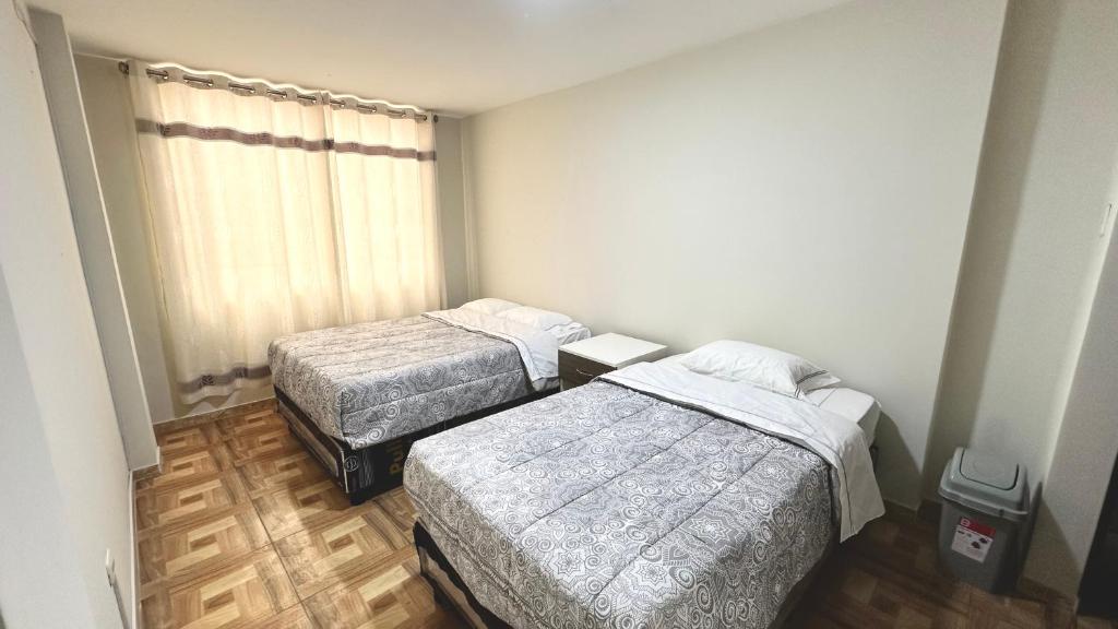 a room with two beds and a window at WIFI Rápido A 20 min del Aeropuerto de Lima in Lima