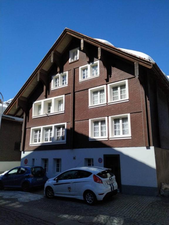 a white car parked in front of a building at Berni's in Andermatt