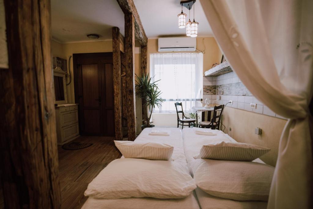 Un dormitorio con dos camas y una mesa y una ventana. en Rustik Home Central, en Arad