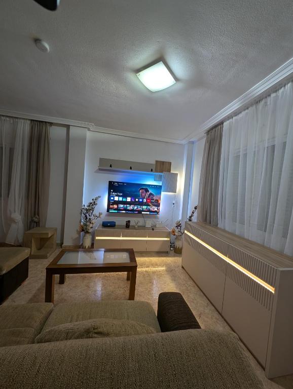 a living room with a couch and a tv at Casa Kave Euro Roda-Los Alcazares in Los Alcázares