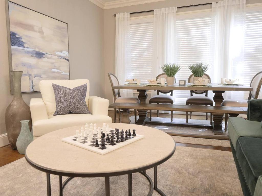 una sala de estar con una mesa de ajedrez en Elegant French-garden Courtyard Retreat In Dallas, en Dallas