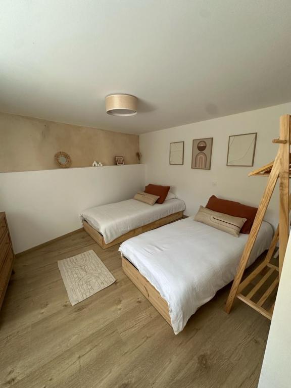 PontrieuxにあるLa Maison de Victoire et Alixのベッド2台とはしごのある寝室