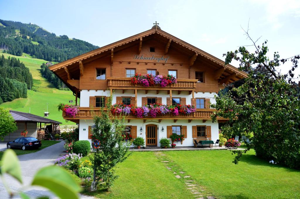 uma casa grande com flores na frente em Schneeberghof em Westendorf