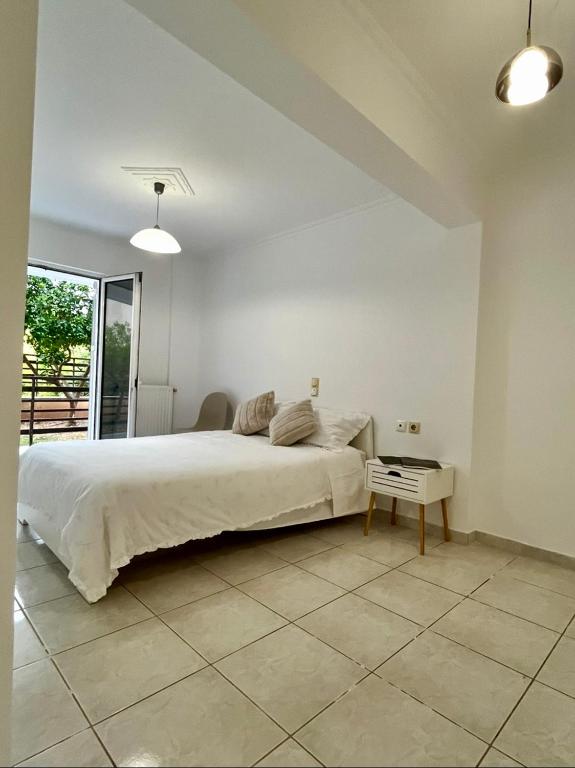 a bedroom with a large bed and a table at Poseidon's Rio Beach Condo in Vernardhaíika