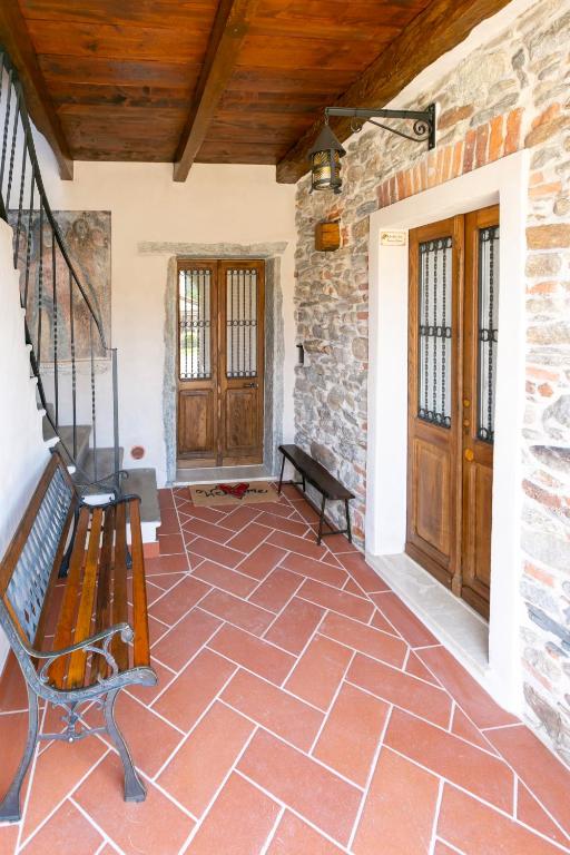 a porch with a bench and a wooden door at Corte di Raglio in Cunardo