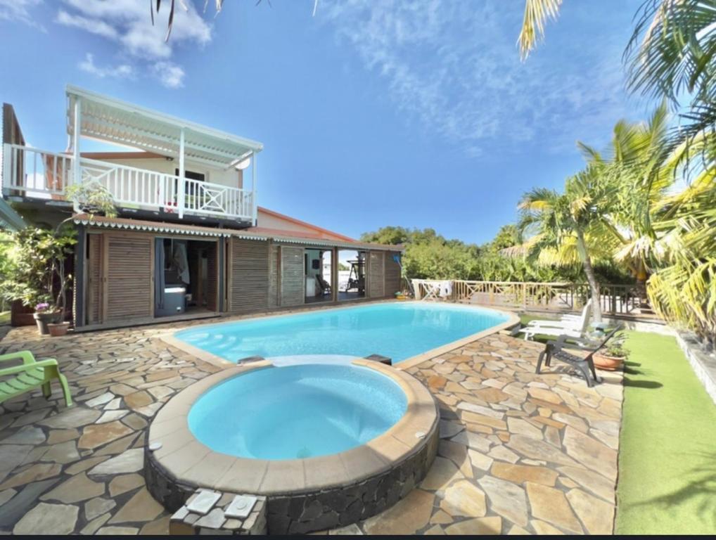 a swimming pool in front of a house at La villa exotik in Saint-Louis