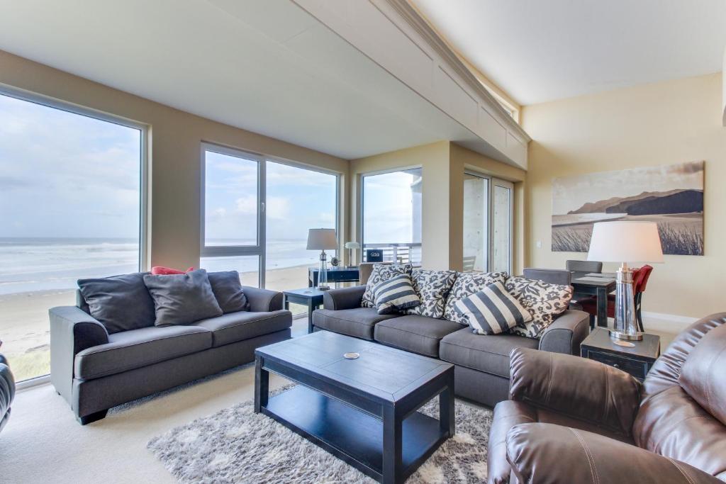 a living room with two couches and a table at Romantic Manhattan Beach Sunset #202 in Rockaway Beach