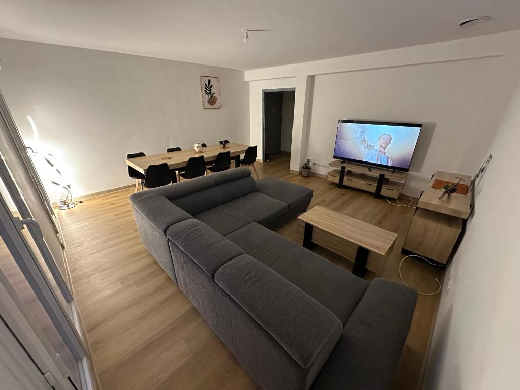 a living room with a couch and a dining room at Appartement climatisé in Château-Arnoux-Saint-Auban