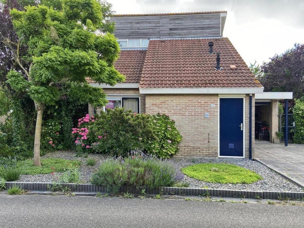 a small brick house with a blue door at Pet-Friendly Coastal Getaway in Breskens