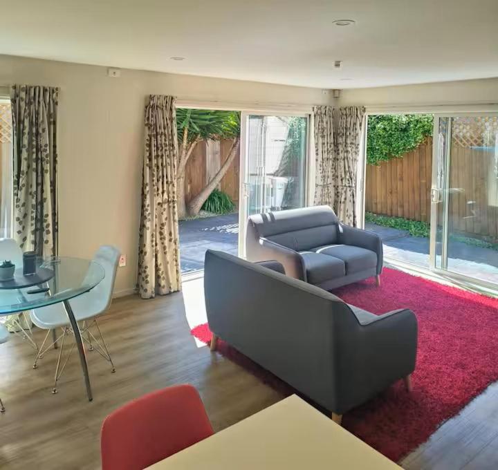 a living room with a couch and a table at City Town House in Christchurch