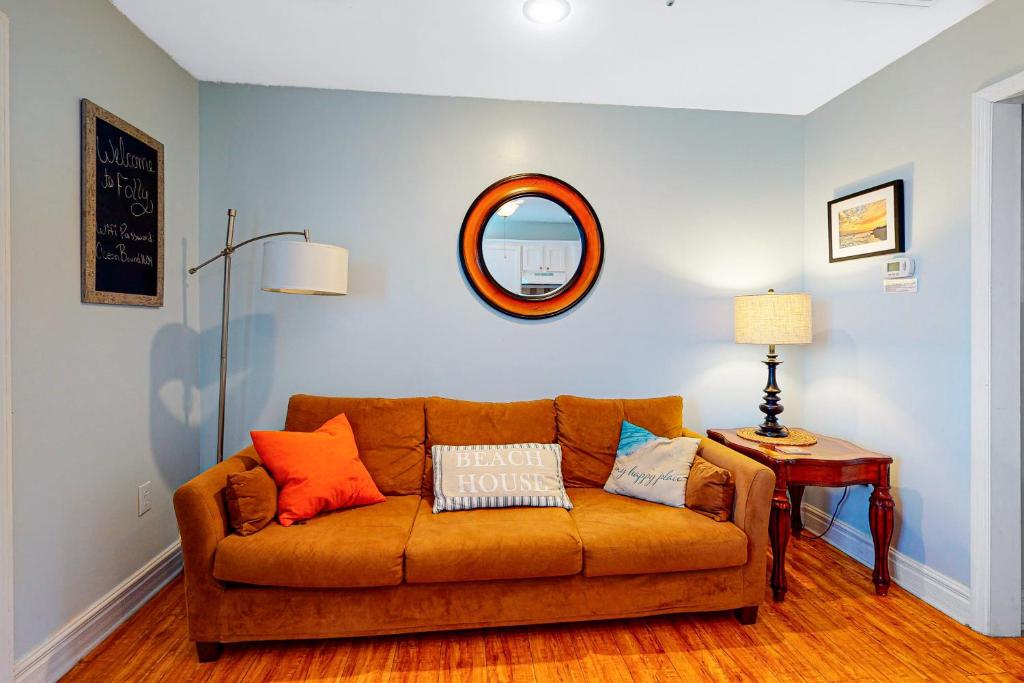 a living room with a couch and a mirror at Oceanbound in Folly Beach