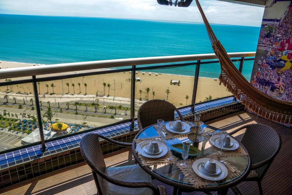 a table on a balcony with a view of the beach at Beira Mar Fortaleza Landscape in Fortaleza
