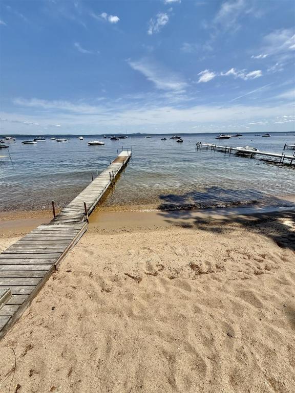 a dock on the beach with boats in the water at CAMP LINDY LIMIT 7 cottage in North Sebago