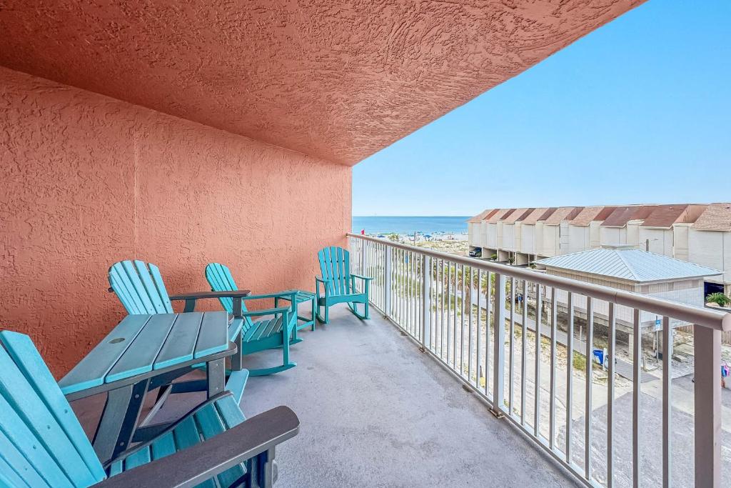 a balcony with chairs and tables and the ocean at Buena Vista Unit 305 in Gulf Shores