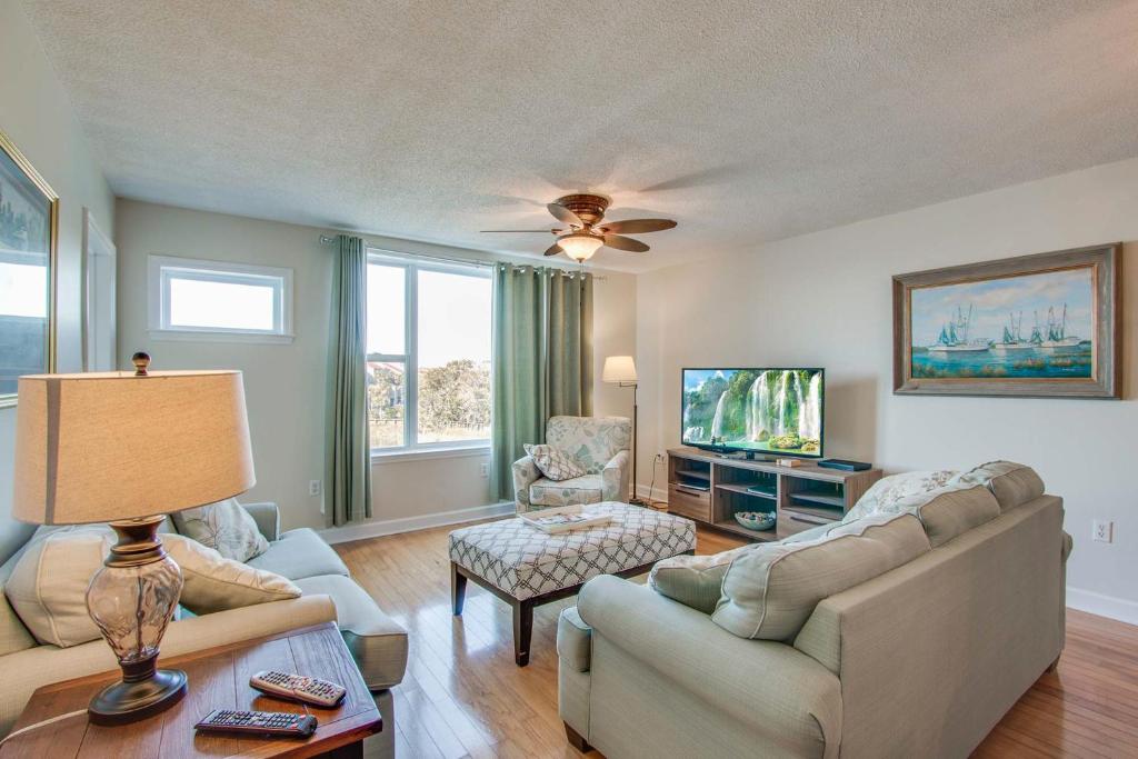 a living room with a couch and a tv at Turn Of River 2F in Folly Beach