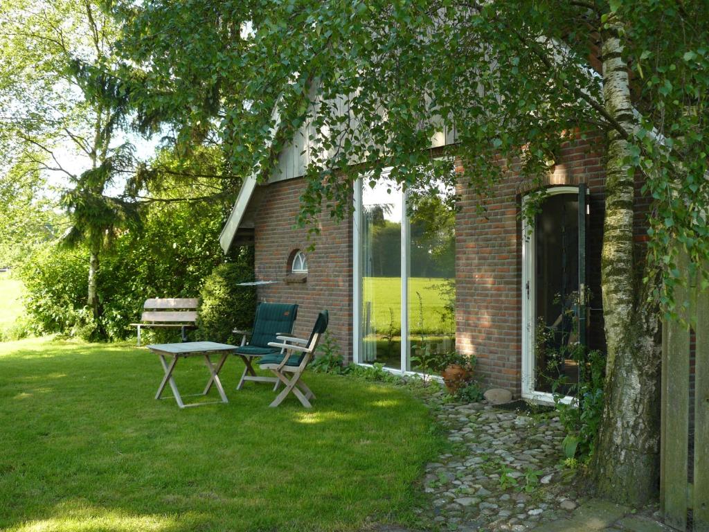 a house with a table and chairs in the yard at De Bekboer in Losser