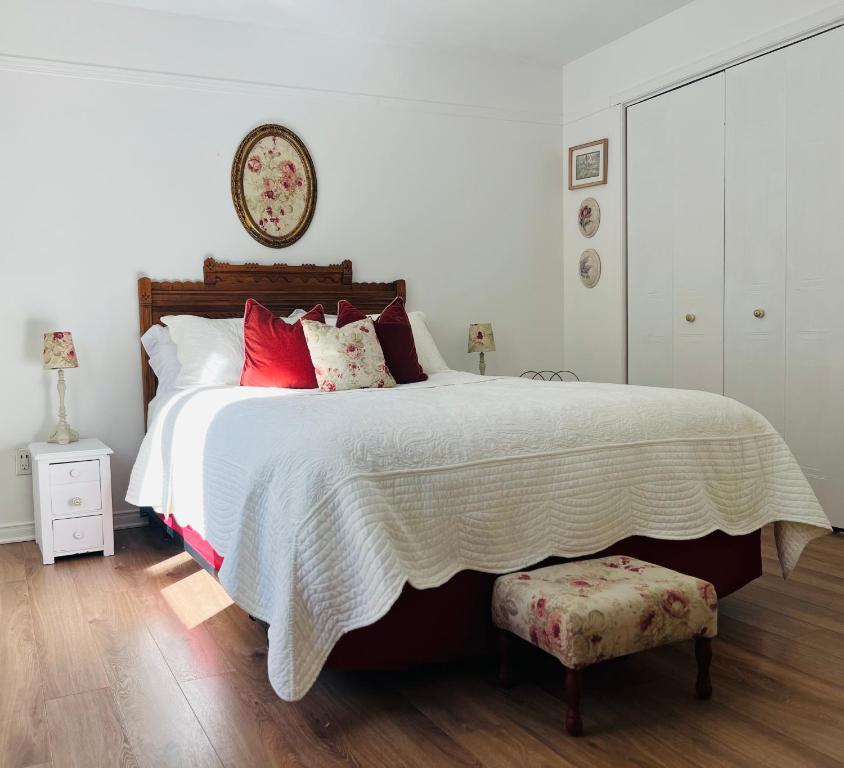 a bedroom with a large bed with red pillows at Chalet -Havre au bord de l'eau in Chertsey