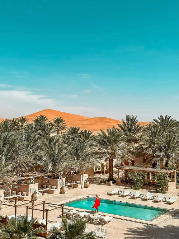 une femme marchant près d'une piscine dans le désert dans l'établissement Riad Serai Merzouga, à Merzouga 24 autres photos